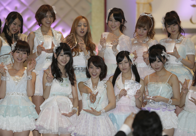 Japan's all-girl pop idol group AKB48 member Yuko Oshima, front row center, flashes a victory sign, as she poses with other members after winning the annual AKB48 popularity poll in Tokyo Wednesday, June 6, 2012. (AP-Yonhap News)