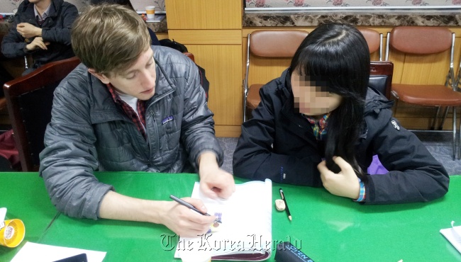 A PSCORE tutor teaches a North Korean refugee, whose identity has been protected in this picture.( PSCORE)
