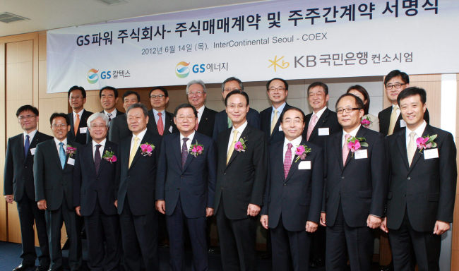 GS Energy President Na Wan-bae (from third from left), KB Financial Group Chairman Euh Yoon-dae, GS Caltex chairman Hur Dong-soo and KB Kookmin Bank CEO Min Byong-deok pose with officials from other industrial and financial companies after the signing ceremony on Thursday at COEX InterContinental Hotel in southern Seoul. (Yonhap News)