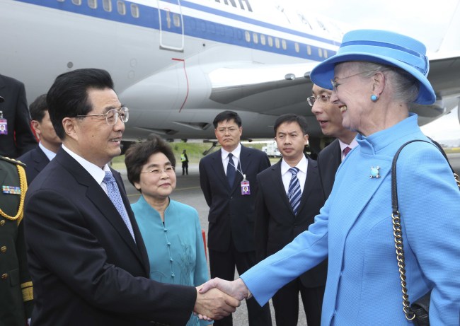 Chinese President Hu Jintao (left) and his wife Liu Yongqing are welcomed by Denmark’s Queen Margrethe II (right) upon their arrival in Copenhagen on Thursday. (Xinhua-Yonhap News)