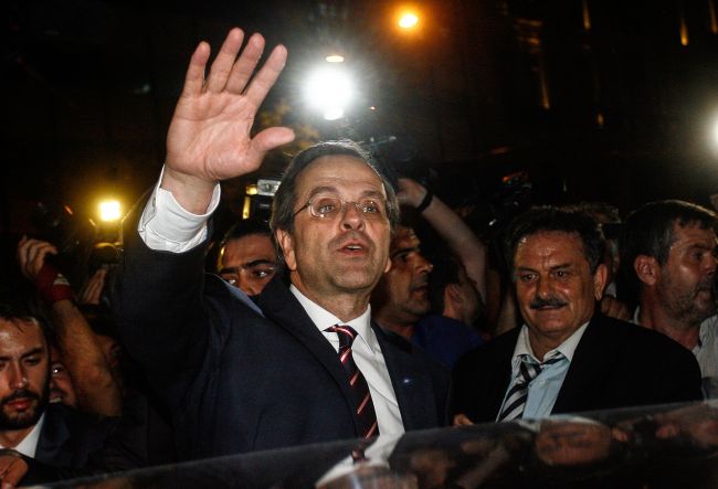 New Democracy party leader, Antonis Samaras (center), waves at supporters as he leaves the new office of the New Democracy conservative party election campaign kiosk near the Greek Parliament, after his party came first in the national Greek`s election, in central Athens, on Sunday. (AFP-Yonhap News)