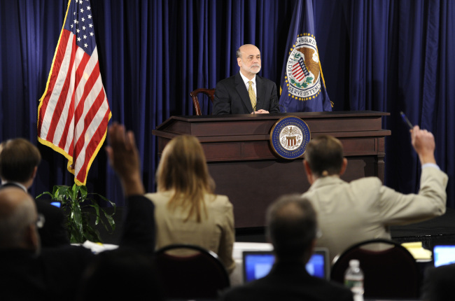 Journalists raise their hands to be called on as Federal Reserve Board Chairman Ben Bernanke attends a press conference at the conclusion of the Federal Open Market Committee’s two-day meeting in Washington, D.C., Wednesday. (UPI-Yonhap News)