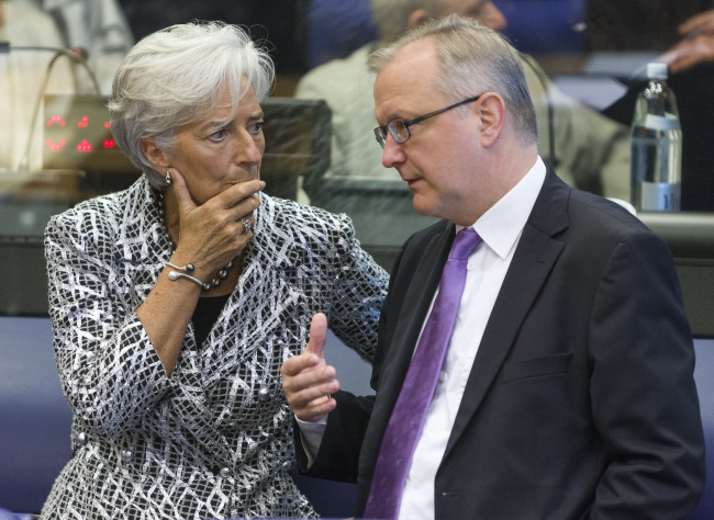 International Monetary Fund Managing Director Christine Lagarde (left) talks with European Economic and Monetary Affairs Commissioner Olli Rehn during the Eurogroup finance ministers’ meeting in Luxembourg, on Thursday. (Xinhua-Yonhap News)