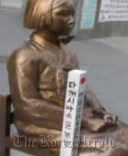 This picture from Suzuki Nobuyuki’s blog shows a stake he placed beside a commemorative statue for Korean wartime sex slaves in Seoul.