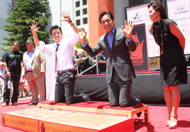 Korean actors Lee Byung-hun (left) and Ahn Sung-ki pose for a photo at the handprint ceremony in front of Grauman’s Chinese Theater in Hollywood on Saturday. (Yonhap News)