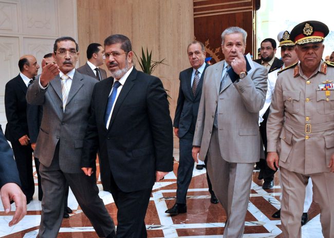 An Egyptian official welcomes the new president-elect, the Muslim Brotherhood’s Mohamed Morsi, during his visit to his new office at the Al-Ittihadiya presidential palace in Cairo on Monday. (AFP-Yonhap News)