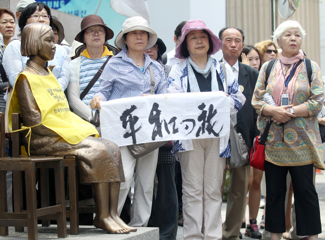 A group of Japanese civic activists protest in front of the Japanese Embassy in central Seoul on Wednesday demanding their government formally apologize for the wartime sex slavery of Korean women during its colonial rule. They joined the weekly protest hosted by Korean activists and former “comfort women.” (Yonhap News)