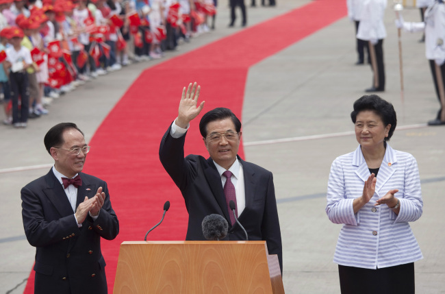 Hu Jintao, China`s president (center) waves as Donald Tsang, Hong Kong`s outgoing chief executive (left) and Liu Yandong, China’s state councilor, look on during a welcoming ceremony in Hong Kong, China, on Friday. (Bloomberg-Yonhap News)