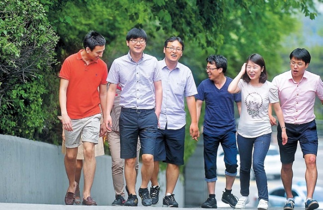 Clad in short pants, jeans and short sleeves, a group of Seoul City public servants take a walk during their lunch break. (Kim Myung-sub/The Korea Herald)