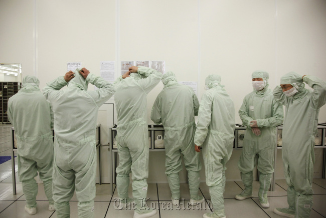 Employees put on clean suits at Semiconductor Manufacturing International Corp. in Shanghai. (Bloomberg)