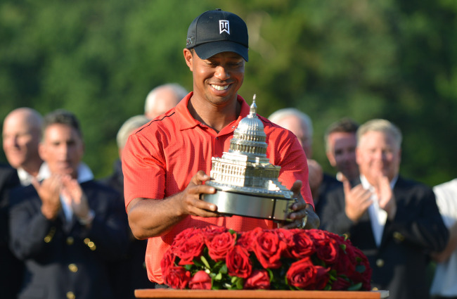 Tiger Woods picks up the winner’s trophy on Sunday. (UPI-Yonhap News)