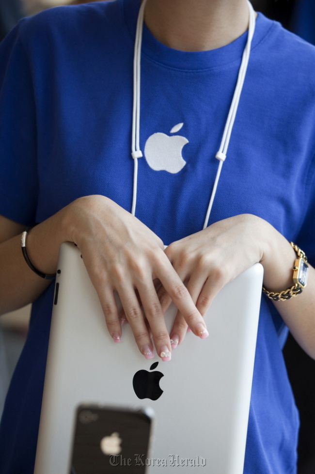 An Apple Inc. employee holds an iPad at the company’s new store in Hong Kong. (Bloomberg)