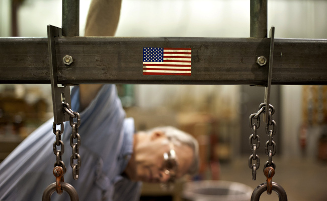 Employee William Meznarich reassembles the die for a punch press at the Badge-A-Minit facility in Oglesby, Illinois, Friday. (Bloomberg)