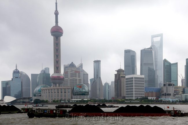 Barges on the Huangpu River loaded with coal steam past the skyscrapers of Lujiazui financial district in Shanghai. (Bloomberg)