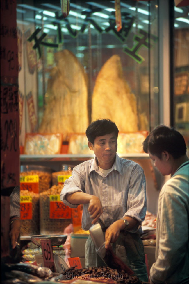 A salesman at a dry goods shop selling shark fins helps a customer in Hong Kong. (Bloomberg)