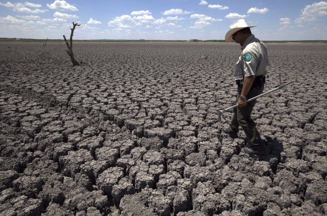 A man walks across the cracked lake bed of O.C. Fisher Lake in San Angelo, Texas. (AP-Yonhap News)