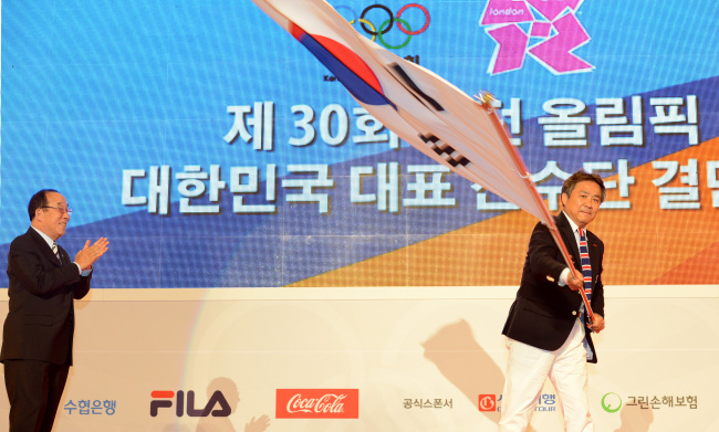 Lee Ki-hong, the head of the Korean Olympic team, waves the national flag after it was handed over from Park Yong-sung, the president of the Korean Olympic Committee, during the Korean delegation's inaugural ceremony for the 2012 London Olympics in Seoul on Wednesday. (Ahn Hoon/The Korea Herald)