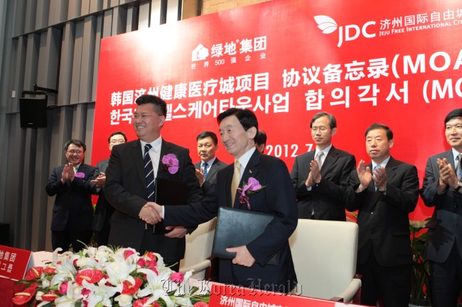 Byon Jong-il (right), chairman of Jeju Free International Development Center, shakes hands with Zhang Yuliang, president of the Greenland Group, after signing an agreement on investment at a ceremony in Shanghai on July 11. (JDC)