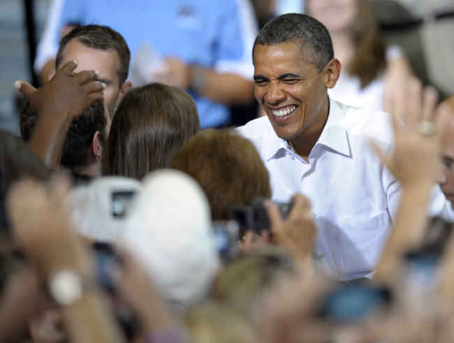 President Barack Obama smiles as he shakes hands while walking to a stage to deliver remarks during a campaign event at Centreville High School in Clifton, Virginia, Saturday. (AP-Yonhap News)