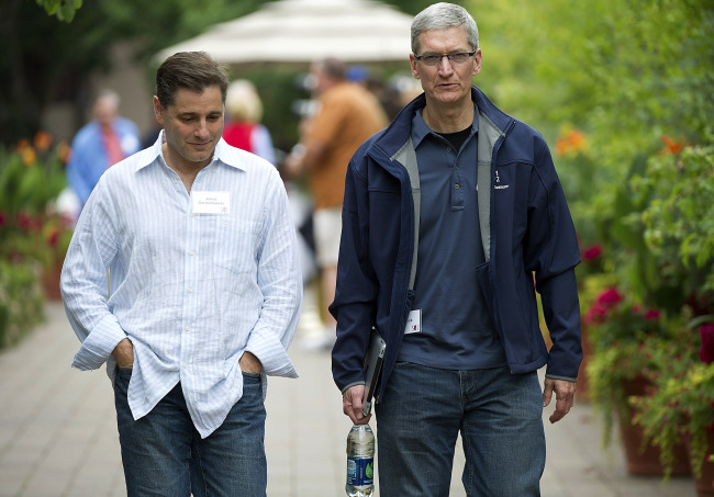 Tim Cook (right), chief executive officer of Apple Inc., and Julius Genachowski, chairman of the U.S. Federal Communications Commission, talk while leaving a morning session at the Allen & Co. Media and Technology Conference in Sun Valley, Idaho, Friday. (Bloomberg)