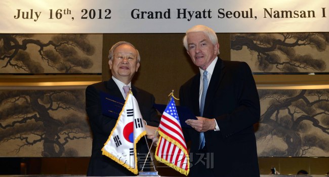 KCCI chairman Sohn Kyung-shik (left) shakes hands with Thomas Donohue, president of the U.S. Chamber of Commerce, after signing an agreement on cooperation between the two chambers at a Seoul hotel on Monday. (Park Hae-mook/The Korea Herald)