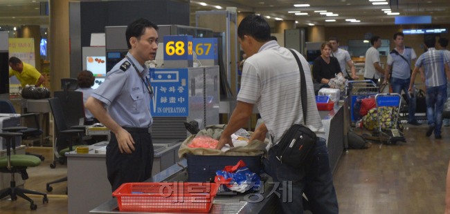 A staffer of the nation’s customs agency monitors goods carried by travelers at Incheon International Airport on Monday. (Kim Myung-sub/The Korea Herald)