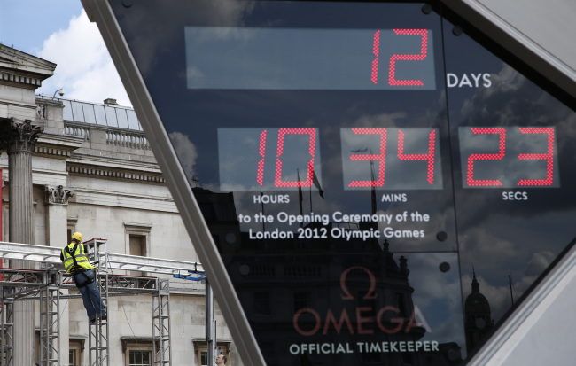 A worker constructs scaffolding in Trafalgar Square where clock displays the days and hours until the start of the 2012 Summer Olympics, Sunday, July 15, 2012, in London. (AP-Yonhap News)