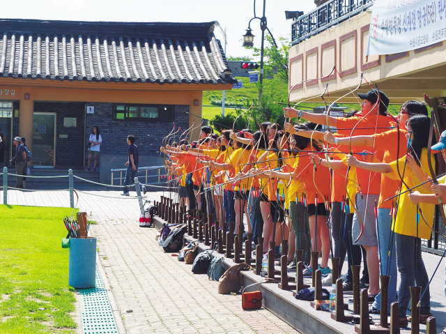 Students on the Embrace Korean Culture program practice traditional archery at Suwon’s Hwaseong Fortress. (Maryann Wright/The Korea Herald)