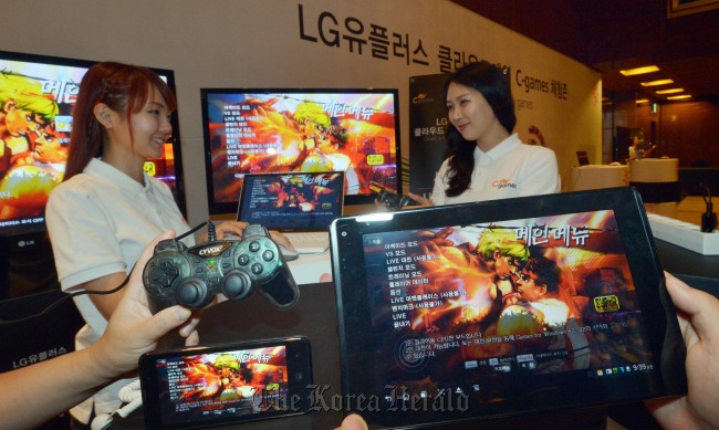 Models pose with smart mobile devices displaying games provided by LG Uplus C-Games cloud platform. (Kim Myung-sub/The Korea Herald)