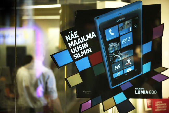 An advertisement for Nokia Lumia 800 smartphones sits on a window at a mobile phone store in Helsinki, Finland. (Bloomberg)