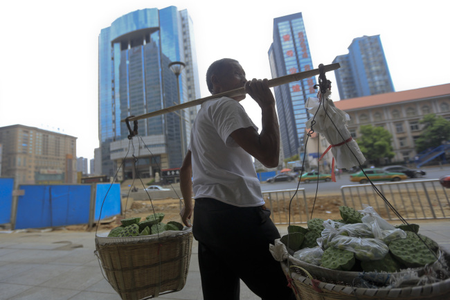 A vendor selling produce stands in downtown Changsha, China. (Bloomberg)