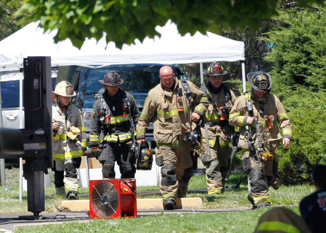 Firefighters walk Saturday at the booby-trapped apartment of James Eagen Holmes, who police have identified as the suspect in the deadly shooting at a crowded movie theater a day earlier, in Aurora, Colorado. (AP-Yonhap News)