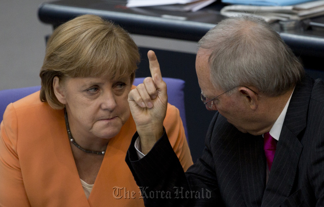 German Finance Minister Wolfgang Schaeuble (right) gestures as he speaks to German Chancellor Angela Merkel, during a special session of the German Parliament Bundestag in Berlin. (AP-Yonhap News)