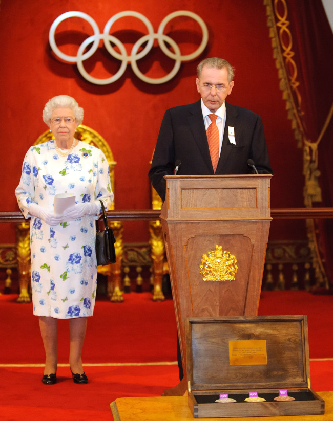 Queen Elizabeth II listens as IOC president Jacques Rogge speaks at Buckingham Palace on Monday. (AP-Yonhap News)