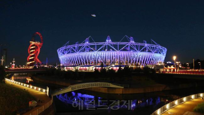 The Olympic Stadium in London is illuminated Monday, four days before the opening of the 2012 Summer Olympics, to hold a rehearsal of the opening ceremony scheduled for Friday. Britain’s monarch Queen Elizabeth II will officially open the Games at the ceremony, to be attended by thousands of VIPs including some 120 national leaders. (Ahn Hoon/The Korea Herald)