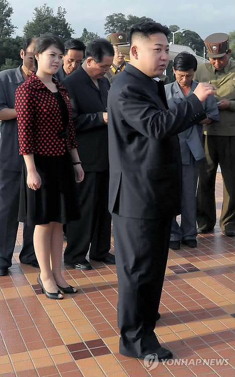 N.K. leader Kim Jong-un and his wife Ri Sol-ju attending to a building dedication ceremony (Yonhap News)