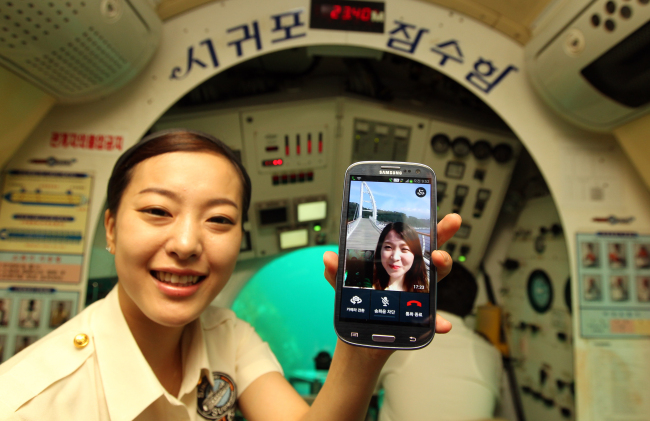 A worker aboard Seogwipo Submarine places a high definition video call through SK Telecom’s new sub-ocean VoLTE service on Thursday. Yonhap NewsA worker aboard Seogwipo Submarine places a high definition video call through SK Telecom’s new sub-ocean VoLTE service on Thursday. (Yonhap News)