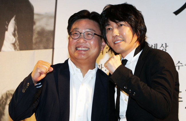 Singer Kim Jang-hoon and Sungshin Women’s University professor Seo Kyoung-duk pose for a photo during a press conference in Seoul, Thursday. (Yonhap News)