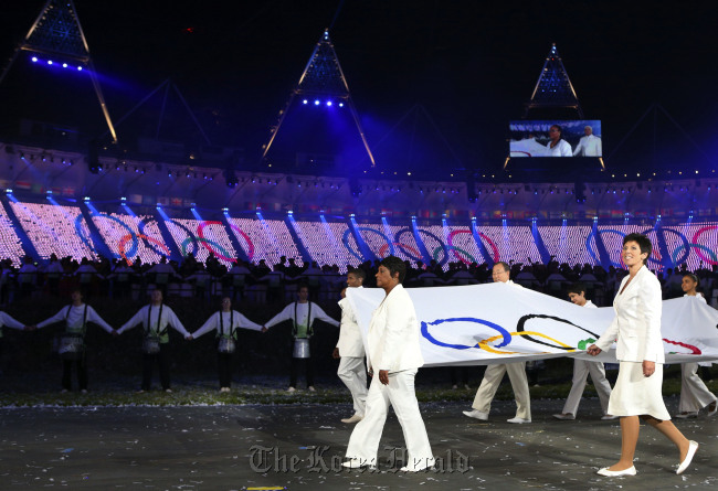 The Olympic flag is carried around the stadium during the Opening Ceremony at the 2012 Summer Olympics on Saturday in London.(AP-Yonhap News)