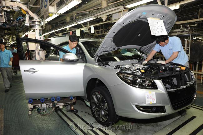 Workers go through final checks on an SM7 at Renault Samsung Motor’s factory in Busan. (RSM)
