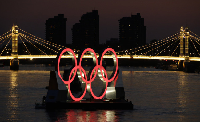A set of Olympic Rings float on a barge in the River Thames off of Battersea park Tuesday, in London. (AP-Yonhap News)