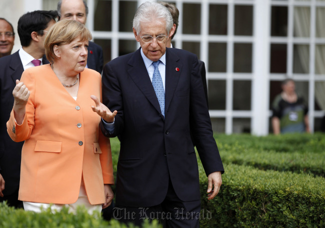 Angela Merkel (lef), Germany’s chancellor, walks in the garden with Mario Monti, Italy’s prime minister, after a joint news conference at Villa Madama in Rome on July 4. (Bloomberg)