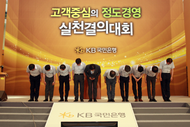 KB Kookmin Bank CEO Min Byong-deok (fifth from left) and other executives take a deep bow after pledging to regain customers’ confidence at a ceremony in Cheonan, South Chungcheong Province, Wednesday. (KB Kookmin Bank)