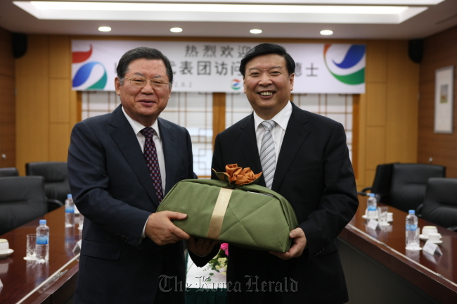 GS Caltex chairman Hur Dong-soo (left) and China’s Shandong Province governor Jiang Daming pose at the oil refiner’s plant in Yeosu, South Jeolla Province, on Thursday. (GS Caltex)