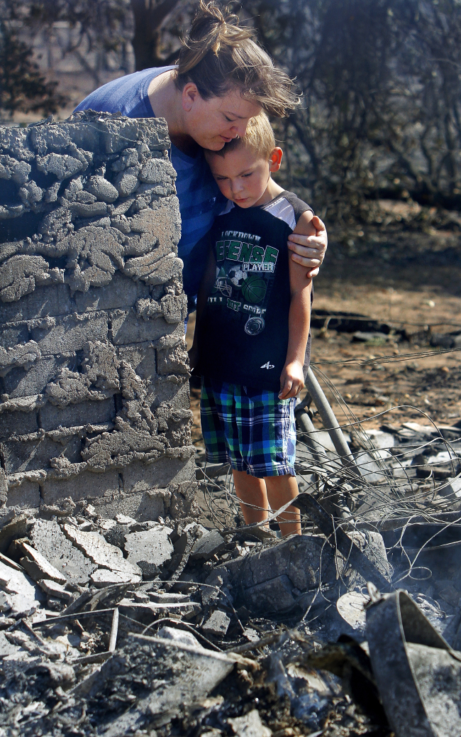 Tracy Streeper hugs 5-year-old grandson Jesse, as they stand on the north side of Streeper’s destroyed home in Luther, Oklahoma, Saturday. (AP-Yonhap News)