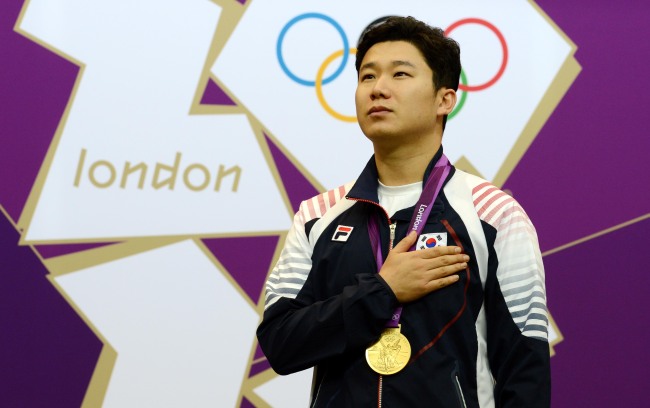Jin Jong-oh stands on the podium after winning gold in the men’s 50-meter pistol on Sunday. (Yonhap News)