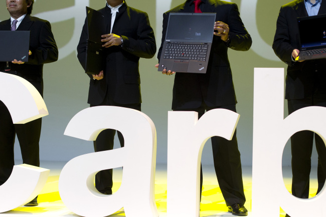 Lenovo executives hold the new ThinkPad X1 Carbon laptops in Beijing Monday. (AP-Yonhap News)