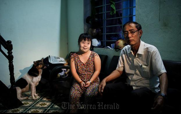 Vo Thi Thuy Nga (left) and her uncle Vo Duoc sit inside their home in Danang, Vietnam. (AP-Yonhap News)