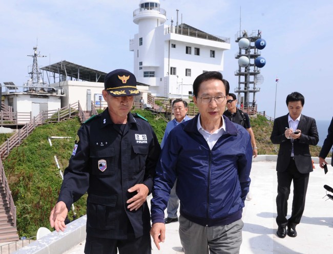 President Lee Myung-bak(right) is briefed by a police officer on Dokdo on Friday. (The Korea Herald)