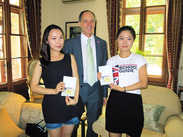 British Ambassador Scott Wightman (center) poses with Shin You-na (left) and Park Soo-hyun, the first Korean recipients of the Youth Mobility Scheme Visa, in Seoul on Thursday. (British Embassy)